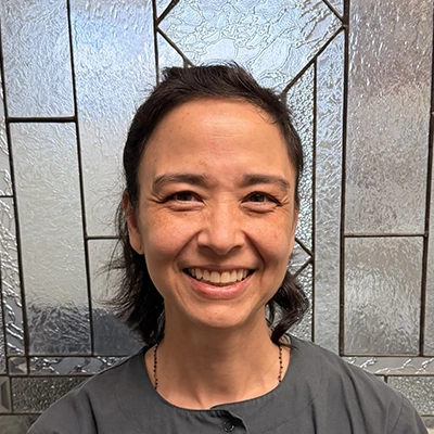 Dental Hygienist Sherri Smiling In Front Of Glass Door
